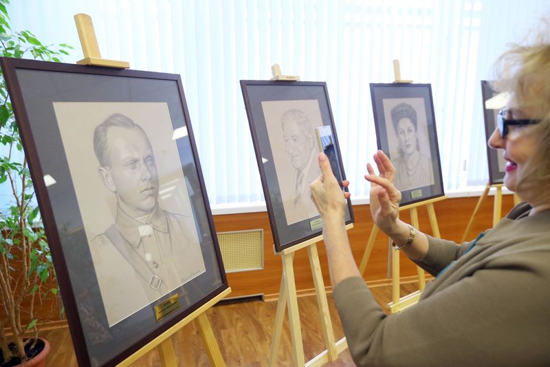 Посетительница на выставке портретов советских разведчиков художника работы Юрия Бирюкова 
